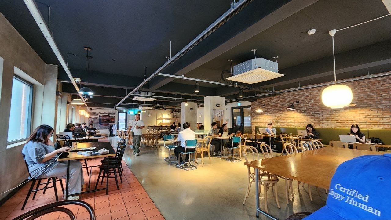 Spacious second-floor seating at Brick Haus with customers using laptops and tablets
