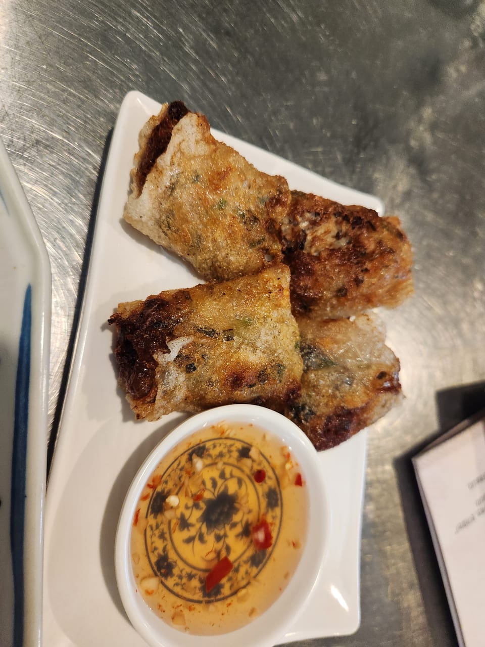 Four crisp fried Vietnamese nem spring rolls with chilli dipping sauce